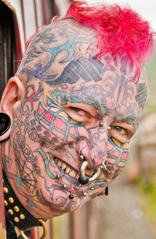 Человек весь в татуировках и пирсинге